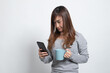 © halfbottle - Young Asian woman with mobile phone and coffee cup.
