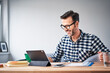 © baranq - Adult man working from home reviewing documents