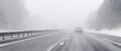 Bannière d'une voiture sur une autoroute en journée, sous la neige et le mauvais temps