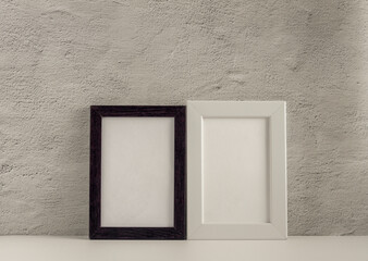 Two empty photo frames on a table or shelf with a copy of the space.