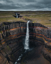 Breathtaking View Of  Layer Falls Surrounded By Rocky Cliffs In Iceland