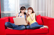 © eastfenceimage - Portrait of two female friends using laptop