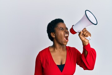 Wall Mural - Young african american woman screaming angry using megaphone over isolated white background.