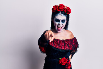 Young woman wearing mexican day of the dead makeup pointing displeased and frustrated to the camera, angry and furious with you