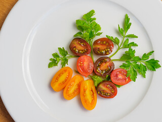 Wall Mural - Sliced Red, Yellow, Orange Grape Tomatoes with Parsley Leaves on White Backgrounds