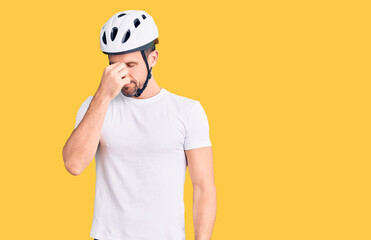 Poster - Young handsome man wearing bike helmet tired rubbing nose and eyes feeling fatigue and headache. stress and frustration concept.