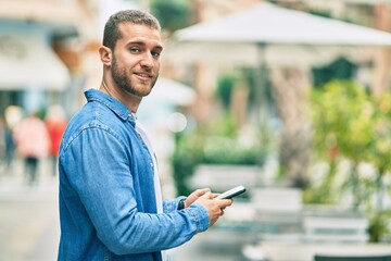 Sticker - Young caucasian man smiling happy using smartphone at the city.