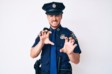 Wall Mural - Young caucasian man wearing police uniform smiling funny doing claw gesture as cat, aggressive and sexy expression