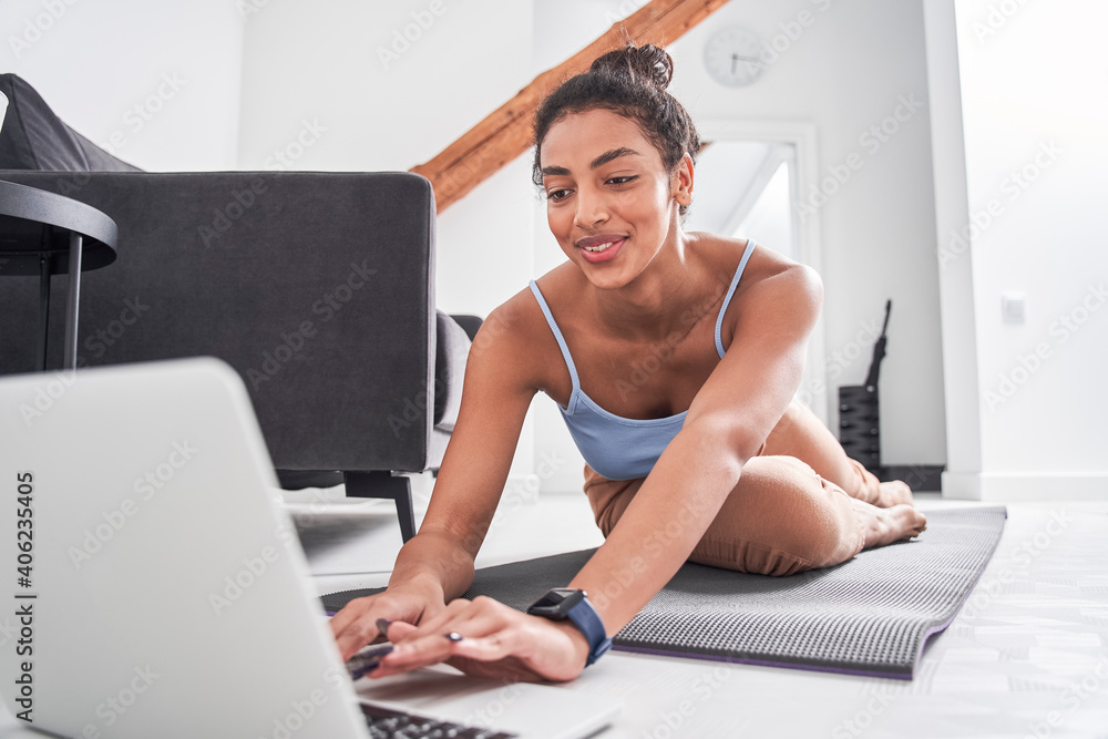 Woman training at home with laptop during the quarantine - obrazy, fototapety, plakaty 