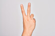 © Krakenimages.com - Hand of caucasian young man showing fingers over isolated white background counting number 2 showing two fingers, gesturing victory and winner symbol