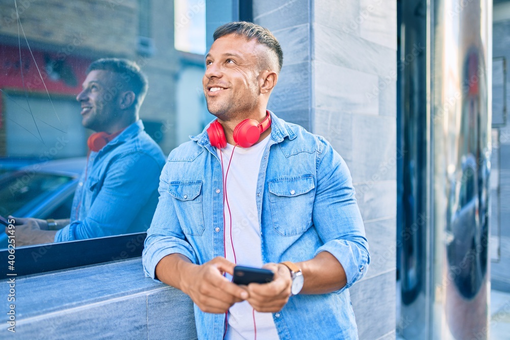 Young caucasian man smiling happy using smartphone and headphones at the city.
