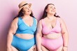 Young plus size twins wearing bikini looking away to side with smile on face, natural expression. laughing confident.
