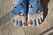 Blue and white penguin toe socks on rug under sunlight