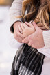 © Christie - Couple's hands with a diamond engagement ring, close up holding hands
