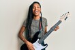 © Krakenimages.com - African american woman playing electric guitar smiling and laughing hard out loud because funny crazy joke.