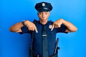 Poster - Handsome middle age mature man wearing police uniform pointing down with fingers showing advertisement, surprised face and open mouth