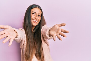 Sticker - Beautiful hispanic woman wearing casual clothes looking at the camera smiling with open arms for hug. cheerful expression embracing happiness.