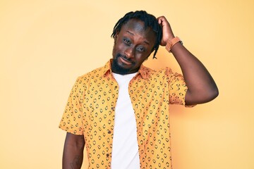 Wall Mural - Young african american man with braids wearing casual clothes confuse and wonder about question. uncertain with doubt, thinking with hand on head. pensive concept.