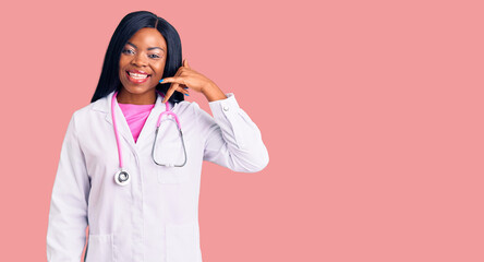 Sticker - Young african american woman wearing doctor stethoscope smiling doing phone gesture with hand and fingers like talking on the telephone. communicating concepts.