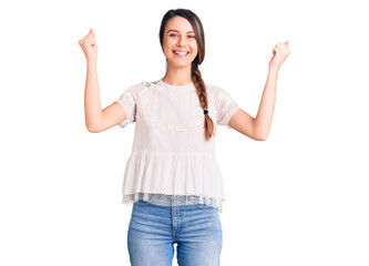 Wall Mural - Young beautiful girl wearing casual t shirt screaming proud, celebrating victory and success very excited with raised arms