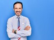 © Krakenimages.com - Middle age handsome patriotic businessman wearing united states tie over blue background happy face smiling with crossed arms looking at the camera. Positive person.