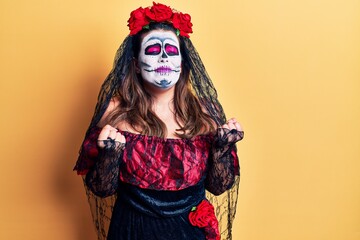 Canvas Print - Young woman wearing day of the dead costume over yellow very happy and excited doing winner gesture with arms raised, smiling and screaming for success. celebration concept.