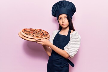 Sticker - Beautiful child girl wearing cooker uniform holding italian pizza thinking attitude and sober expression looking self confident