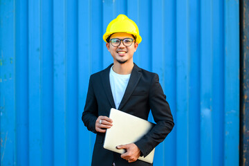 Asian handsome businessman Wear a helmet and hold a laptop