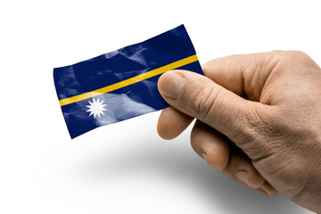 Hand holding a card with a national flag the Nauru