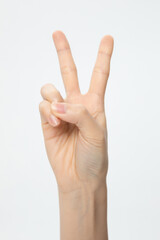 Vertical shot of a hand showing a peace sign isolated on a white background