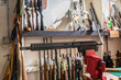 300 Blackout AR rifle upper receiver in a vise on a working table at a gun shop in California, blurred rifles in the background