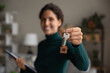 Crop close up of woman real estate agent or broker show keys to new home or apartment. Happy female renter or tenant celebrate relocation moving to own house. Rental, realty concept.