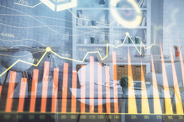 Double exposure of financial graph drawing and office interior background. Concept of stock market.