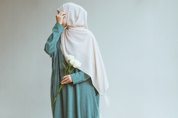 Young muslim woman standing and posing while covering her face