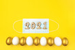 Easter golden eggs 2021 with Coronavirus (COVID19) protection concepts. Happy Easter 2021. Stay at home Covid-19 concept for Easter time on yellow background. Minimal easter concept.