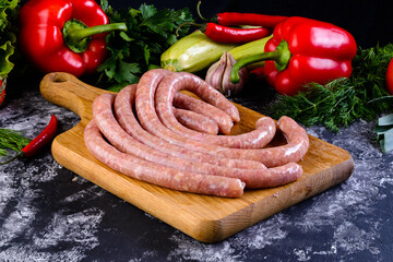 Sticker - Fresh raw sausage on wooden board, Raw barbecue sausages with spices and vegetables. Top view Freshly made raw breed butchers sausages. Free space