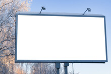 Billboard On The Street In The City With An Empty White Space For Text On A Background Of Trees In Frost, Snow, Blue Sky, Beautiful Winter Background, Mock Up