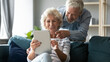 © fizkes - Emotional joyful middle aged senior family couple watching funny photos or videos online on digital computer tablet, having fun web surfing information or enjoying shopping in internet store.
