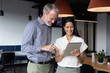 © Wavebreak Media - Diverse business people standing using digital tablet in modern office