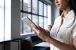 © Wavebreak Media - Mxed race businesswoman standing using digital tablet in modern office