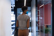 © Wavebreak Media - Mixed race businesswoman wearing face mask walking in modern office