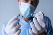 © Wavebreak Media - Caucasian male doctor wearing face mask standing and filling syringe