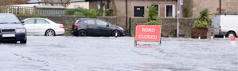 Wall Mural - Road flood closed sign under deep water during bad extreme heavy rain storm weather