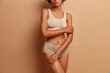© wayhome.studio  - Slim dark skinned female model in underwear wears high waist panties and cropped top poses against brown background has flat belly and slender legs