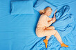 © wayhome.studio  - Beautiful blonde senior woman lying on one side sleeps comfortably in bed dressed in nightwear and socks enjoys good sleep sees sweet dreams poses at cozy bedroom alone. Flat lay. Rest concept