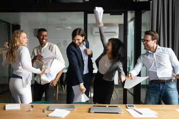 Poster - Overjoyed happy young and senior multiracial diverse business people colleagues celebrating corporate success, workday finish or closing profitable deal, dancing and having fun together in office.