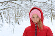 Lovely girl in a red jacket in the snow-covered forest