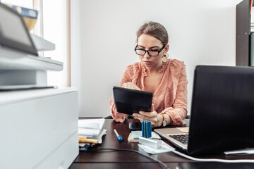 Wall Mural - Office worker, business woman with calculators at her workplace in the office