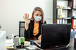 © splitov27 - Business woman in a medical mask communicates by video call in the office at the workplace