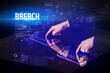 © ra2 studio - Hand touching digital table with BREACH inscription, new age security concept